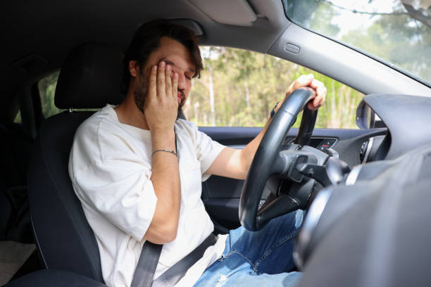 istock Tired man drives a car 1677013947