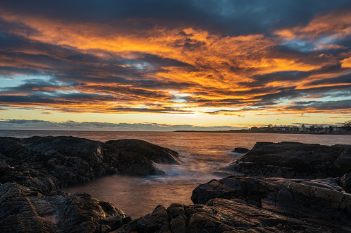 Vivid sunset over stony coast of Baltic sea, fiery cloudscape