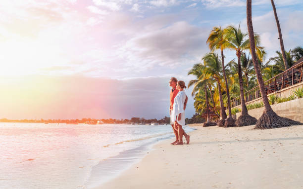 istock Couple in love hugging on sandy exotic beach while having evening walk by Trou-aux-Biches seashore on Mauritius island enjoying sunset. People relationship and tropic honeymoon vacations concept image 1677137368