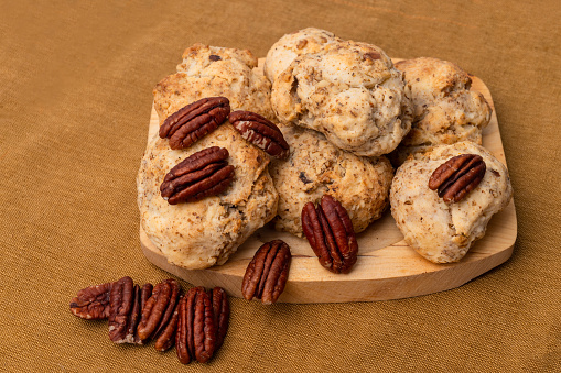 crispy pecan sandies cookies on a brown paper towel. cookies with buttery, and nutty goodness.