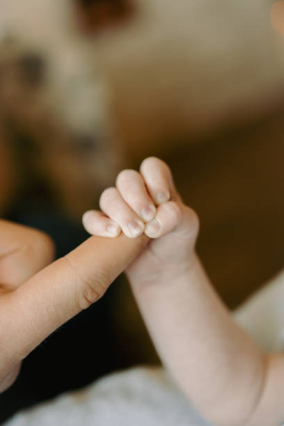 istock Tiny baby hand grips parent's finger in a loving hold 1677181658