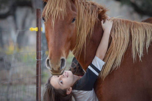 istock Young Girl Hugging From Red Horse 1677194793