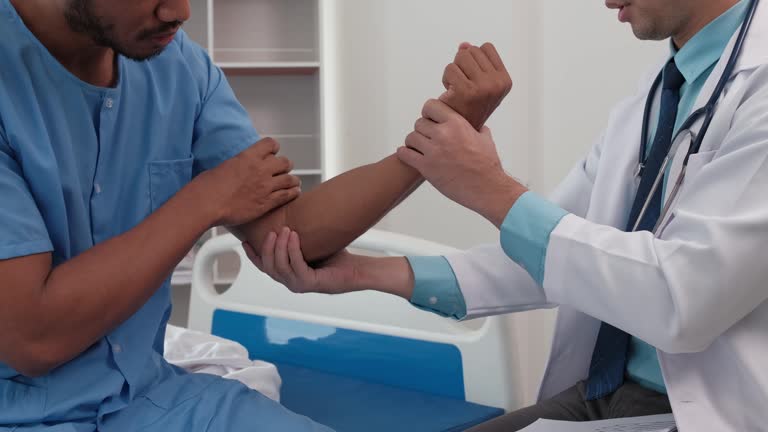 A physical therapist or doctor examines an Asian patient's arm for abnormalities.