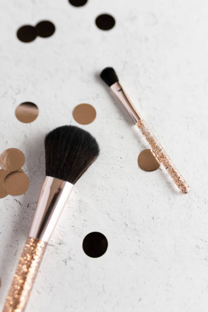 istock Two sparkling makeup brushes and rose gold confetti 1677229514