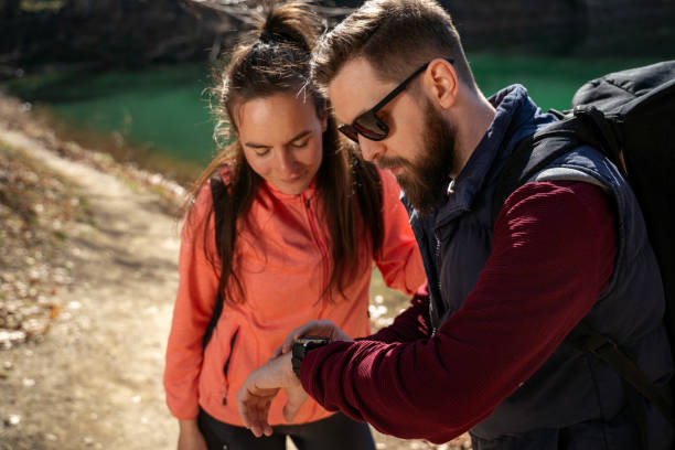 istock Young fit couple hiking together, looking data on smartwatch 1677235810