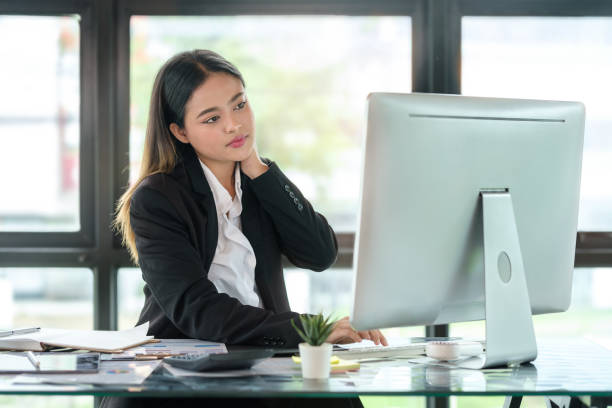 istock Tired businesswoman suffering from neck pain, looking uncomfortable while working with computer in the office. Sick worker concept 1677264097