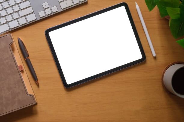 istock Flat lay, top view of digital tablet with blank display, laptop, notebook and coffee cup on wooden table. 1677265754