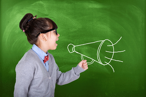 Child Schoolgirl Screaming In Megaphone, Back to School Advertisement  over Blackboard