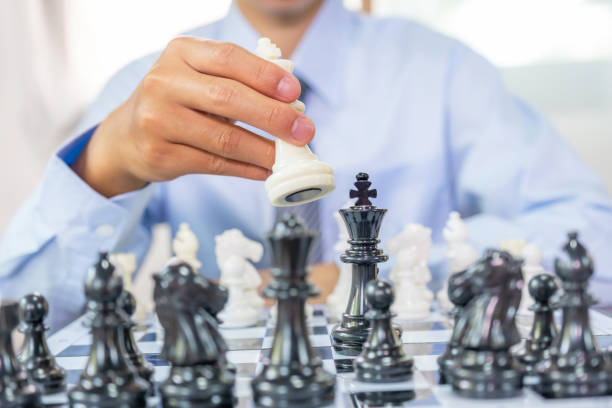 手は敵に勝つための戦略と戦術でチェスを動かし、ボードゲームで戦い、ビジネスチャンス競争戦略的挑戦のコンセプト - risk board game board game victory war ストックフォトと画像