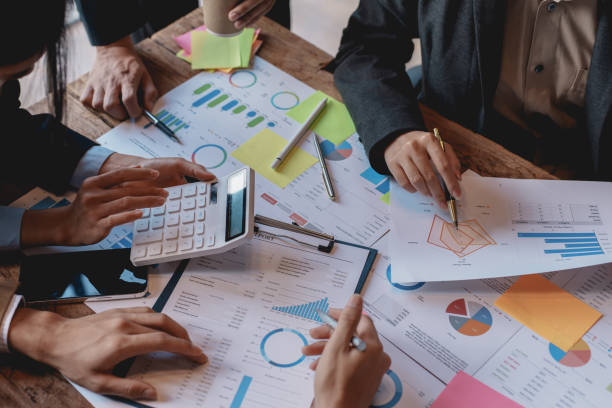 Business people in a meeting and using a calculator to calculate, plan, analyze, create graphs and charts to show business growth to plan new business expansions in the future.