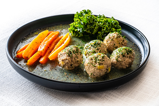 Roasted meatballs in dill sauce and cooked carrots