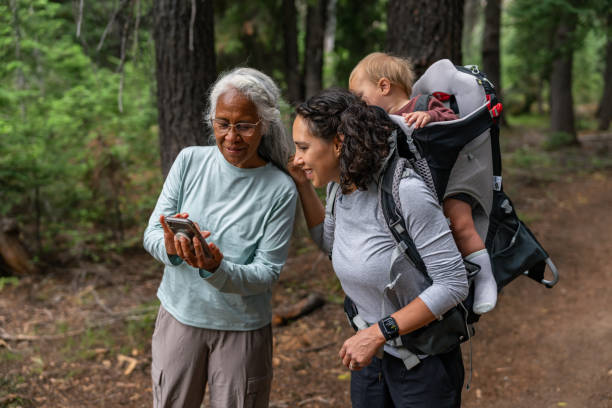 Multigenerational family looks at phone during a hike