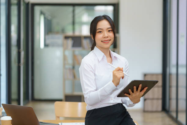 istock An  Asian businesswoman is standing and using a digital tablet. 1677420866