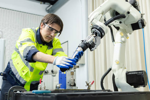 istock Male technician engineer checking automation robotics arm at industrial modern factory. man working at factory innovation automation robot. 1677510755