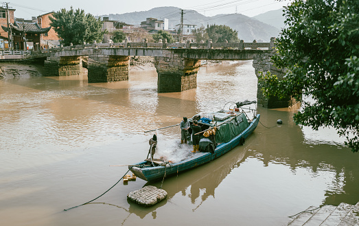 September 12th 2023,Fuzhou,China: Fishermen driving a fishing boat on river in the historic district in downtown of Fuzhou City, which is one of the most oldest cities in southeast China.