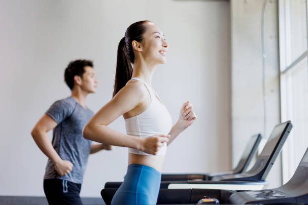 Young Asian adults running on treadmills