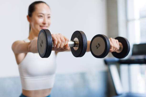 istock Young Asian woman training with dumbbells 1677534980