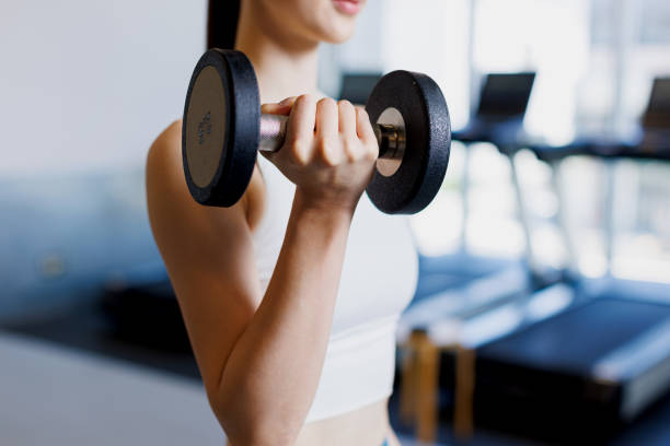 istock Young Asian woman training with dumbbells 1677536610