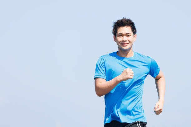 istock Young Asian man jogging outdoors 1677540436