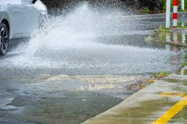 istock a car driving through the puddle and splashing water in a raining day 1677541537