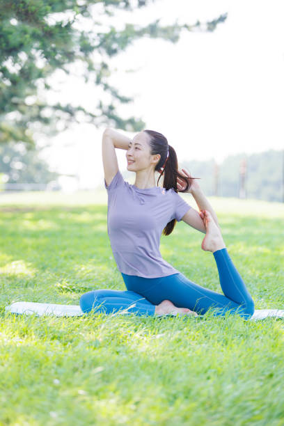 Young Asian woman practicing yoga in the park
