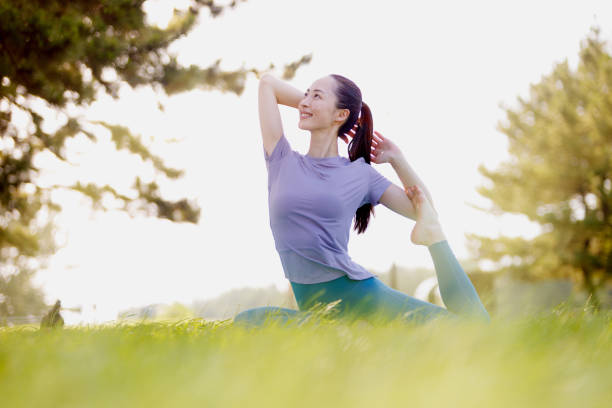 istock Young Asian woman practicing yoga in the park 1677542676