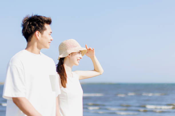 istock Young Asian couple walking by the beach 1677544890