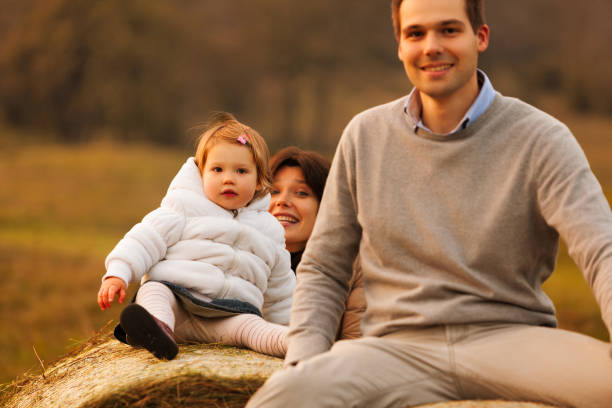 istock Child on hay bales, parents play lovingly 1677548498