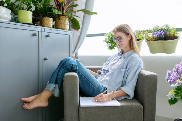 istock Student girl studying at home, sitting at home in an armchair, using digital tablet 1677565631