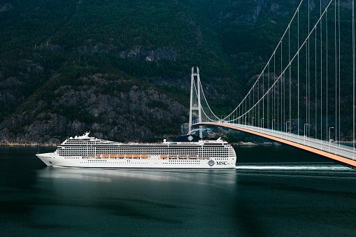 Eidfjord, Norway - June 21, 2023: Cruise ship MSC Poesia is sailing under the Hardanger Bridge
