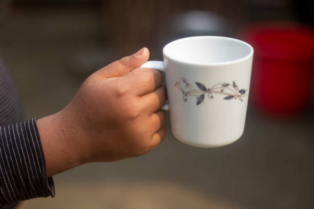 istock A human hand holds an old tea cup and the background blur 1677613467