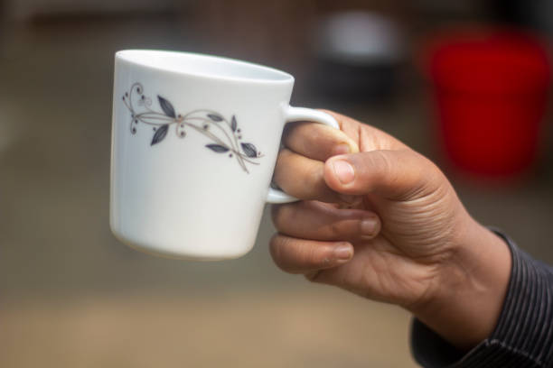 istock A human hand holds an old tea cup and the background blur 1677613476