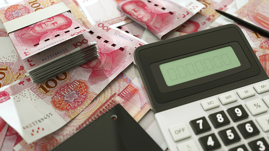 100 Chinese Yuan notes spread out  with a calculator, pen and notebook. 3d rendering