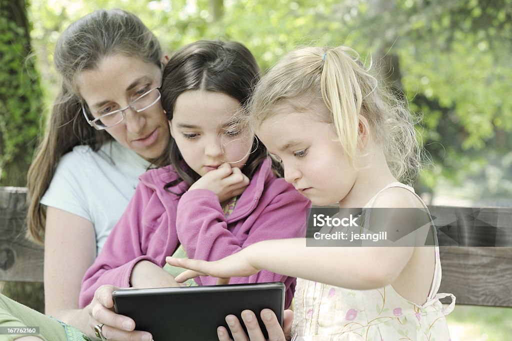Le chiedo di condividere la lettura di famiglia tempo all'aria aperta - Foto stock royalty-free di Adulto