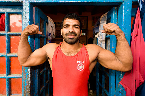 Indian Wrestler Posing New Delhi India Indian Wrestler posing at the entrance of training and fitness room - cabin in Downtown New Delhi. New Delhi, India. Logo on Short is generic part of Indian Flag - National Team. greco stock pictures, royalty-free photos & images