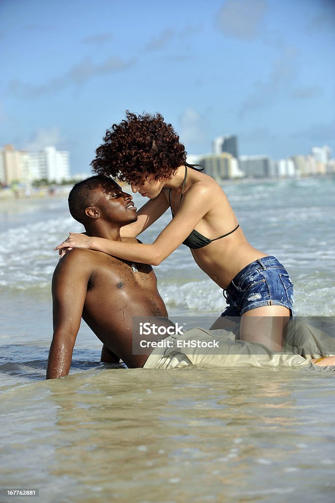 Joven de raza mixta Pareja en la playa - Foto de stock de Olas rompientes libre de derechos