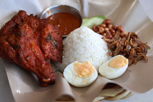 Nasi lemak with a splash of sambal chili, some fried anchovies, peanuts and a piece of deep fried chicken