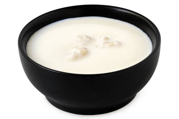 istock Milk with kefir grains in a black ceramic bowl isolated on white. 1677642201