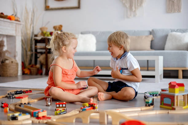 istock Two sweet children, siblings, playing with trains at home 1677643885