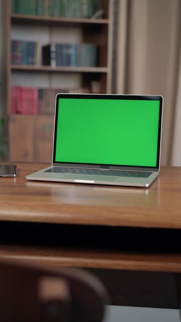 Laptop with Mock Up Green Screen Chroma Key Display on Desk In Loft-style Office