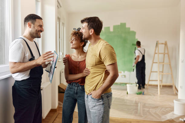 istock Happy house painter talking to a couple during home renovation. 1677651198