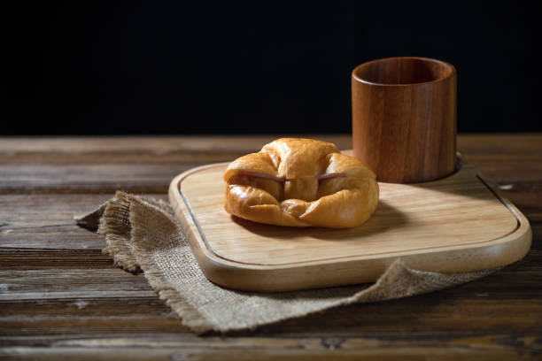 Delicious Freshly Baked Croissants and cup on Rustic Wooden Platte