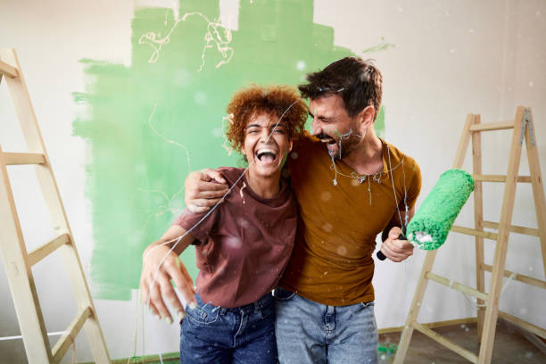 istock Cheerful couple having fun while painting their new home. 1677663003