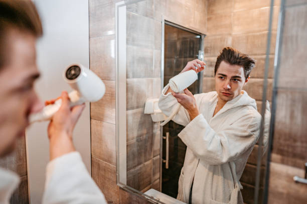istock Young Man Blow Drying His Hair 1677675118