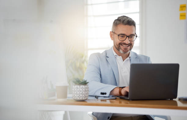 istock Happy business man typing on laptop for email update, online project and reading digital report with mockup space. Mature manager, entrepreneur and working on computer for research, planning and info 1677681697