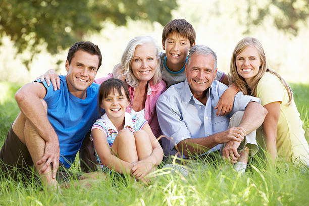 Three Generation Family Relaxing In Summer Field