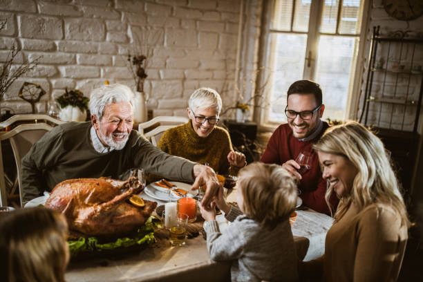 istock Happy extended family having fun during Thanksgiving meal at dining table. 1677695171