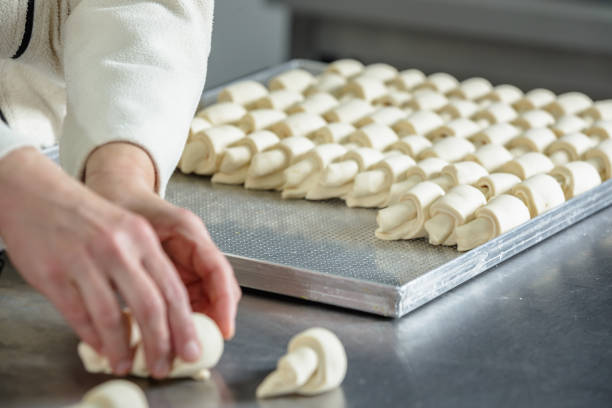 istock Preparing crescent rolls for baking, tray on the kitchen counter in small business 1677698511