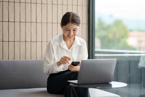 istock Beautiful Asian woman using smartphone to check work contact customers, answer chats, complete transactions and use social media application. 1677701946