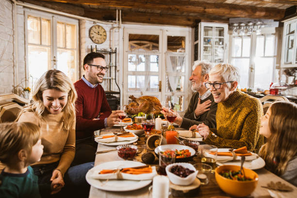 istock Happy extended family talking during Thanksgiving meal at dining table. 1677706391